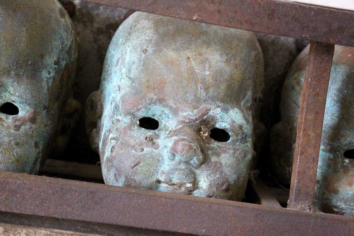 A Patinated Iron Art Installation Modelled as Six Dolls Heads - Image 3